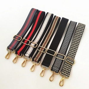 Detail of seven adjustable nylon bag straps with diverse patterns and gold metal buckles