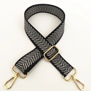 Detail of adjustable black and white chevron nylon strap with gold lobster clasps
