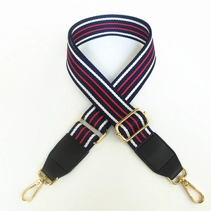 Detail of adjustable red white and blue striped bag strap with gold metal lobster clasps