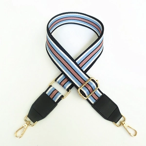 Close-up of adjustable striped canvas strap with gold metal hooks and black leather