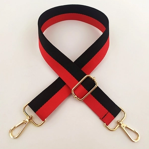 Detail view of adjustable red and black striped nylon shoulder strap with gold metal buckles