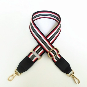 Detail of adjustable woven purse strap with colorful stripes and gold metal hardware