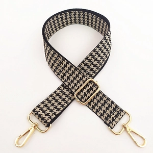 Detail of classic houndstooth weave strap with adjustable gold buckles and swivel clasps
