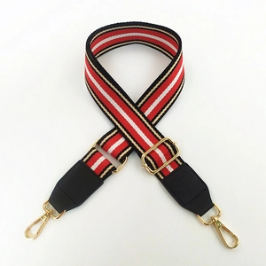 Detail of adjustable woven purse strap with red black stripes and gold metal lobster clasps