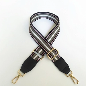 Detail of adjustable striped canvas strap with golden lobster clasps and black leather ends