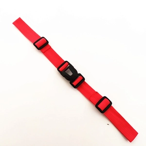 Macro detail of red nylon backpack chest strap with black plastic quick-release buckle