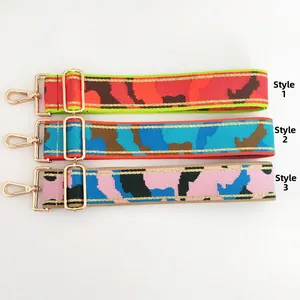 Close-up of wide colorful camouflage bag straps with gold metal hooks in three color options