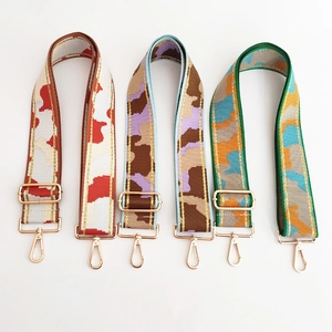 Detailed view of three adjustable woven shoulder straps with gold-tone metal buckles