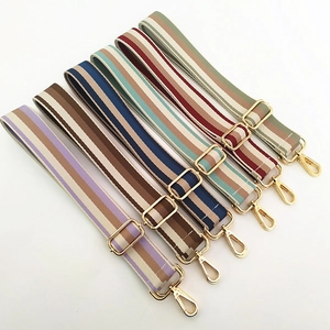 Macro view of assorted striped canvas replacement straps with gold metal hardware for bags