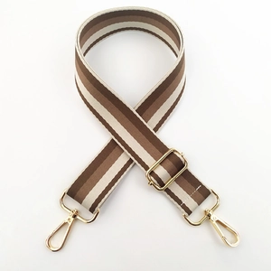 Detail view of woven striped bag strap with gold metal lobster clasps and buckle
