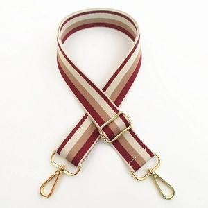 Close-up of adjustable striped canvas strap with burgundy and khaki colors and gold metal hooks