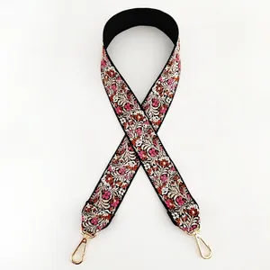 Detailed close-up of ethnic floral embroidery pattern on wide bag strap with golden hook
