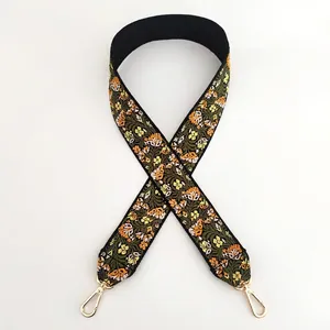 Detailed close-up of ethnic floral embroidery on a black wide guitar style bag strap