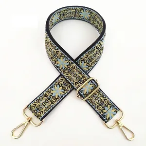 Detail of embroidered floral guitar strap with golden metal hooks and adjustable buckle
