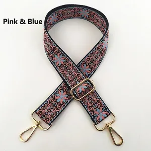 Detail view of pink and blue embroidered floral strap with golden metal lobster clasps