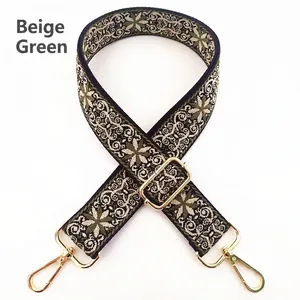 Detail of adjustable beige and green bohemian floral embroidered bag strap with gold hooks