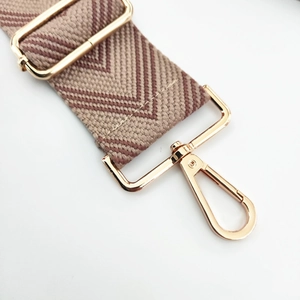 Close-up of adjustable woven purse strap with brown V-pattern and gold metal swivel clasp