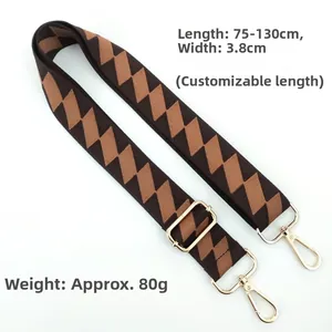 Detail of adjustable checkered bag strap with golden metal hooks on white background
