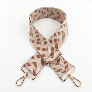 Detail of adjustable chevron woven strap with polished light gold metal swivel hooks