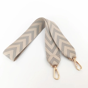 Close-up of woven herringbone bag strap with high-quality gold metal lobster clasps