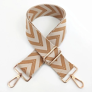 Close-up of adjustable woven bag strap with brown herringbone pattern and gold metal hooks