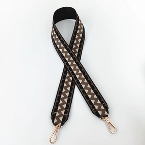Detail of woven bag strap with geometric wave pattern and gold metal swivel hooks
