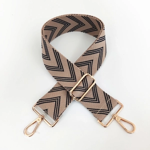Detail of adjustable woven wide purse strap with gold lobster clasps and chevron pattern