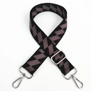 Detail view of adjustable canvas bag strap with grey geometric pattern and silver hooks