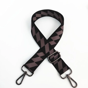 Detail of adjustable geometric strap with black and coffee zigzag weave and metal hooks