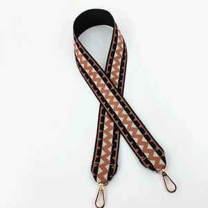 Detailed view of woven ethnic style bag strap with rose gold metal lobster clasps
