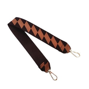 Wide woven shoulder strap with orange and brown geometric patterns and gold lobster clasps