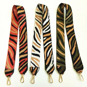 Detail of colorful zebra print nylon bag straps with golden lobster clasps and thick weave