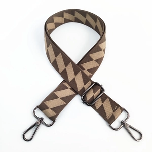 Close-up of wide brown geometric lightning pattern strap with gunmetal swivel hooks