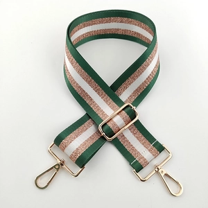 Detail of adjustable nylon bag strap with green and rose gold metallic stripes