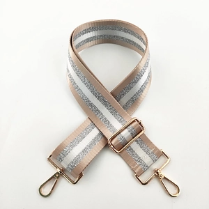 Close-up of adjustable beige and silver glitter nylon strap with gold metal buckles
