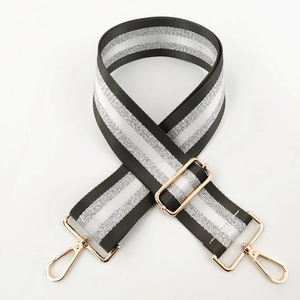 Detail of adjustable black and silver striped nylon strap with gold lobster clasps