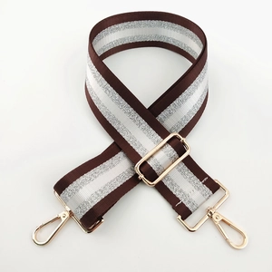 Detail of adjustable nylon bag strap with striped silver glitter and gold metal hooks