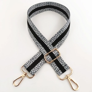 Close-up of 3.8cm wide adjustable strap with spotted weave and gold metal swivel hooks