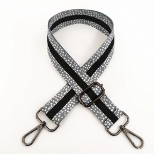 Detail of adjustable gray strap with white dots, black stripes, and gunmetal hooks