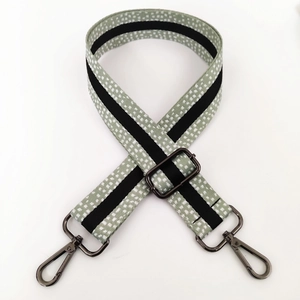 Detail of light green spotted fabric bag strap with gunmetal gray lobster clasps