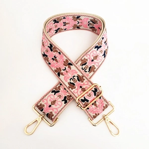 Detail of floral ethnic embroidery on thick adjustable woven strap with gold metal buckle