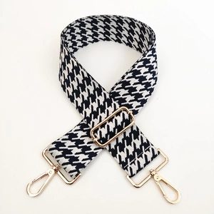 Close-up of adjustable houndstooth bag strap with premium gold-tone metal buckles