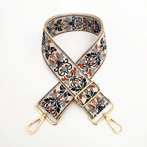Close-up of ethnic jacquard strap with gold metal buckles and detailed weave texture