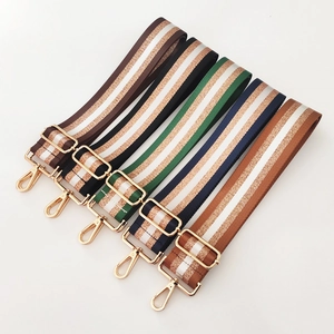 Detail view of nylon striped bag straps with gold metal hooks and glitter gold lines