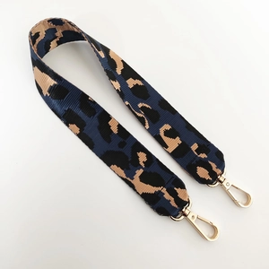 Détail de la bandoulière en nylon jacquard léopard avec mousquetons en métal doré
