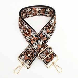 Close-up of vintage floral jacquard bag strap with gold metal buckles and embroidery
