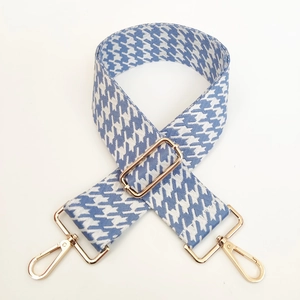 Detail of blue and white houndstooth woven strap with adjustable gold lobster clasps