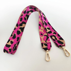 Gros plan sur bandoulière en nylon léopard avec boucles dorées et touches de rose