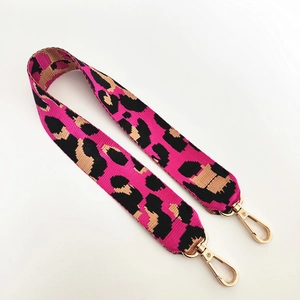 Détail de la bandoulière en nylon à motif léopard avec mousquetons en métal doré poli