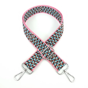 Detail of colorful woven shoulder strap with geometric diamond patterns and metal hooks